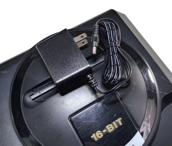 Regulated power supply for Sega Mega Drive / Genesis 1 with US plug on top of the console